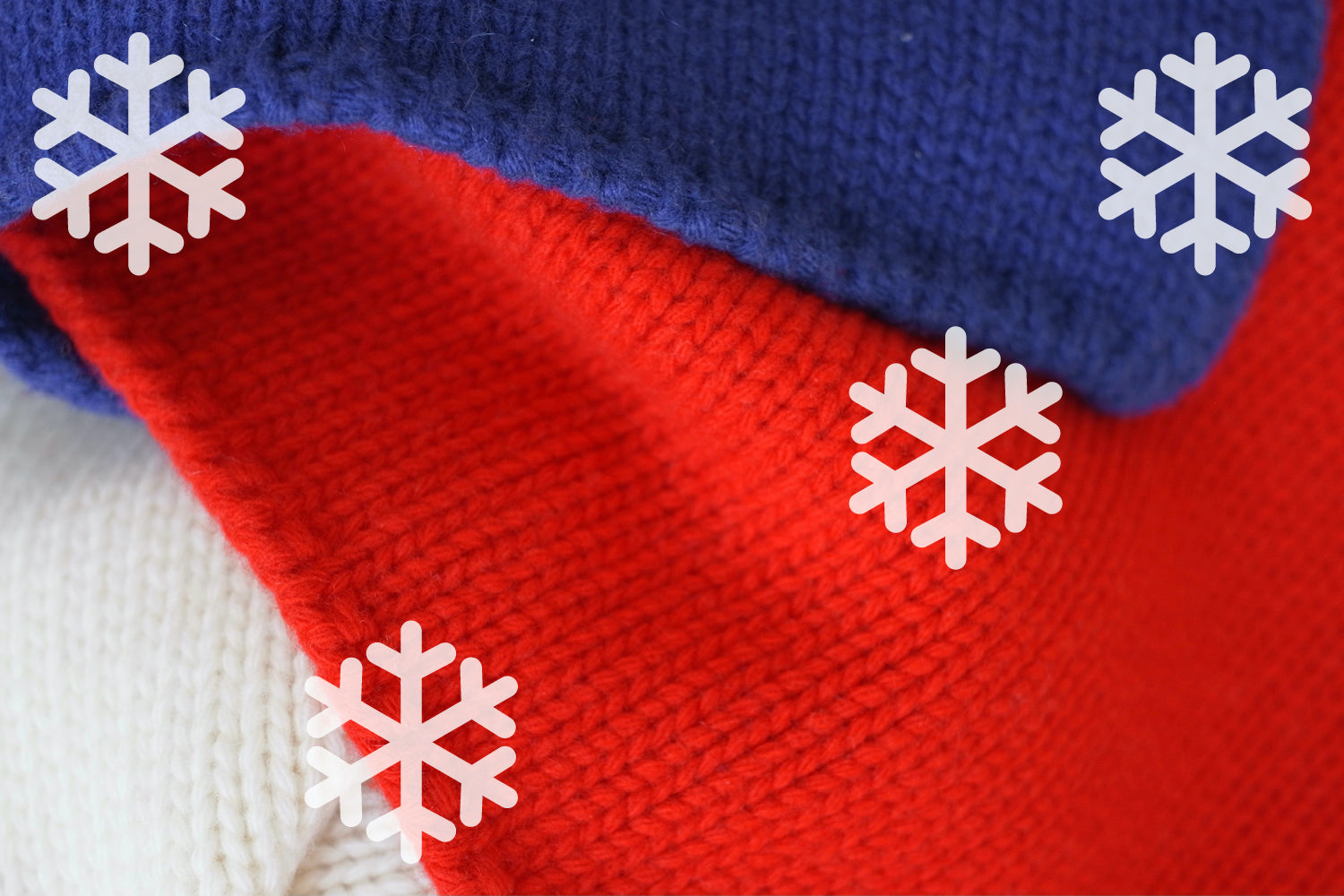 Close-up of a knitted scarf with red, blue, and white colors and snowflake graphics