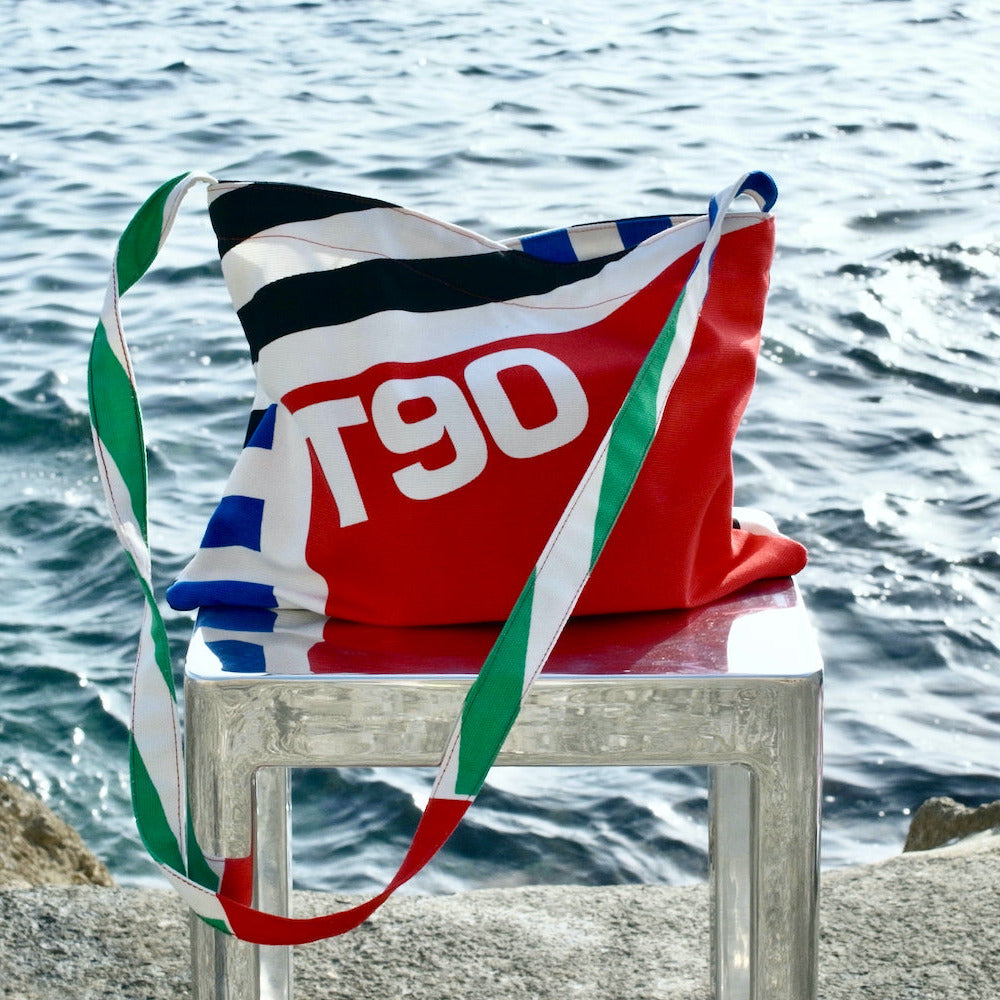 Colorful bag with 'T90' branding on a chair by the water