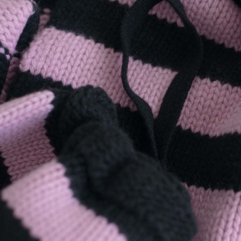 Close-up of a snood on a pink and black striped fabric background