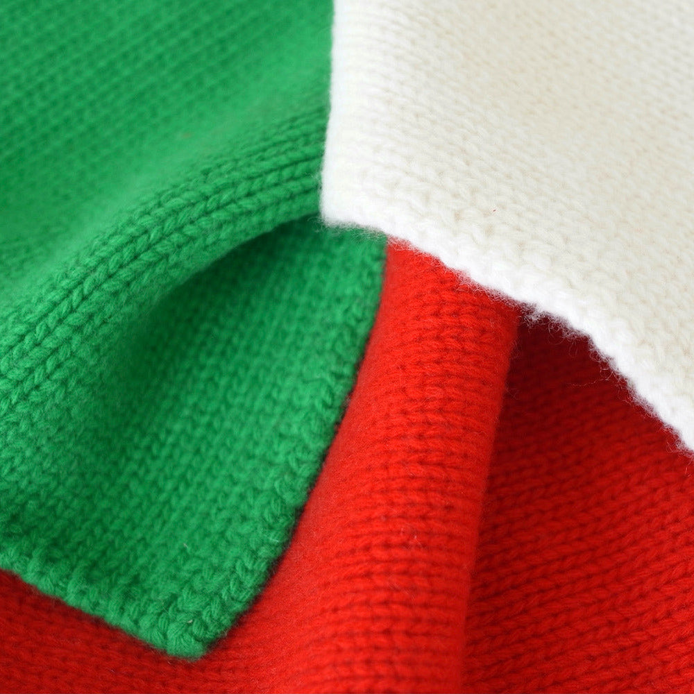 Close-up of a knitted fabric with green, red, and white colors.