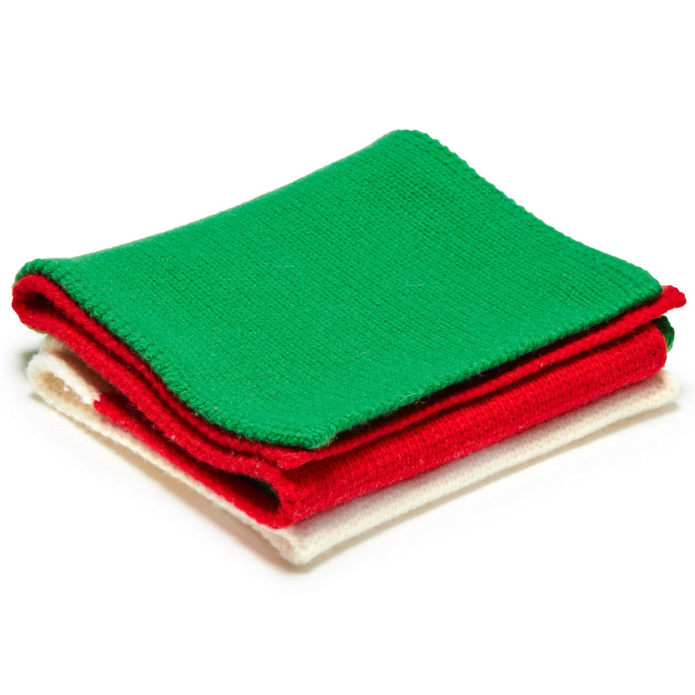 Green, red, and white knitted scarf on a white background